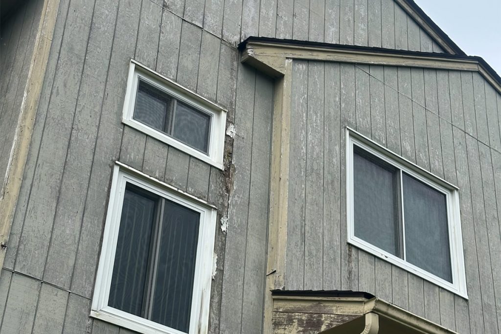 Close-up of exterior wood siding with severe peeling paint requiring restoration and preparation by Willow Tree Painting & Home Improvement in Warwick, NY.