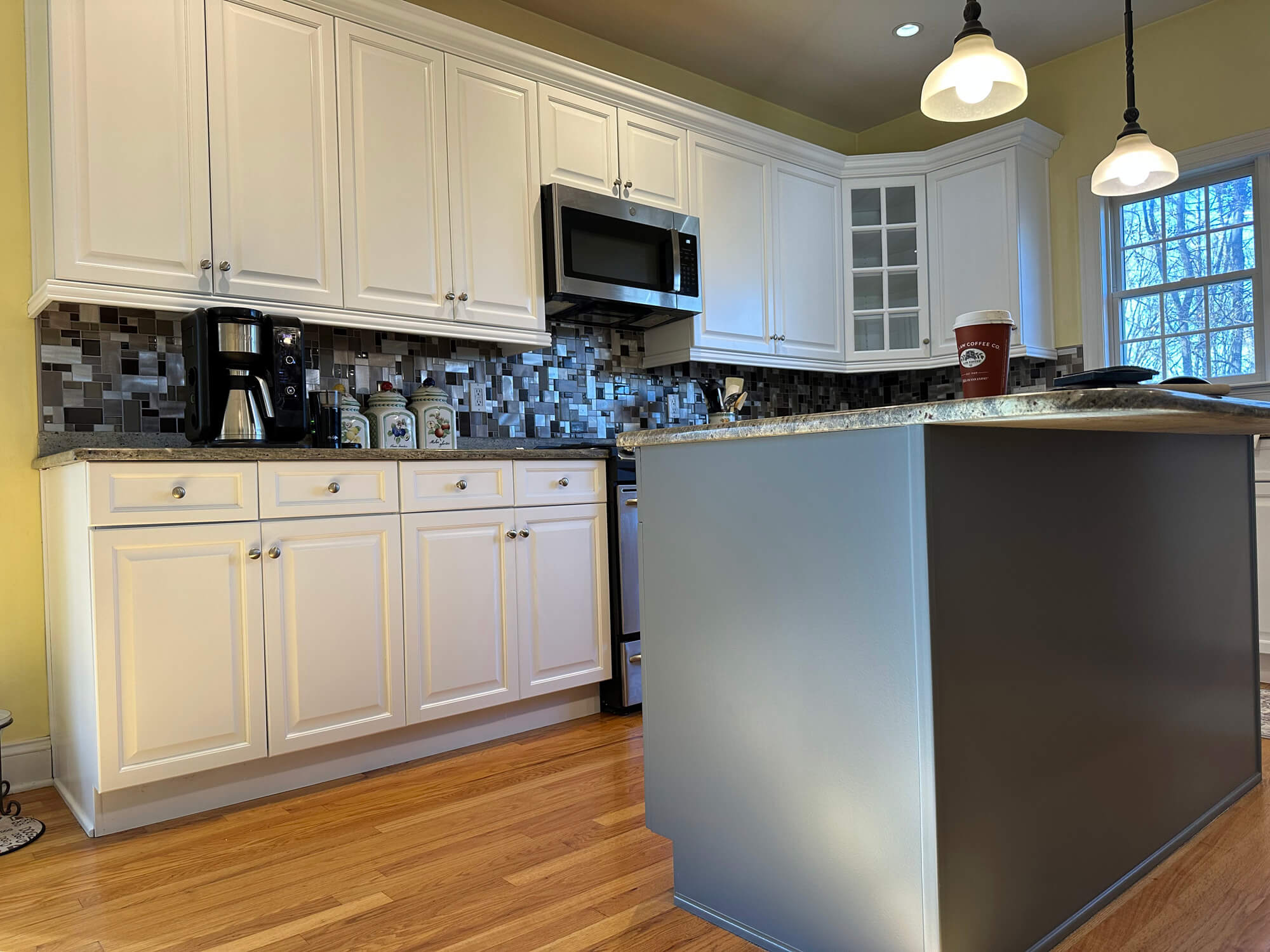 White and gray two-tone cabinet painting with mosaic backsplash in Orange County, NY