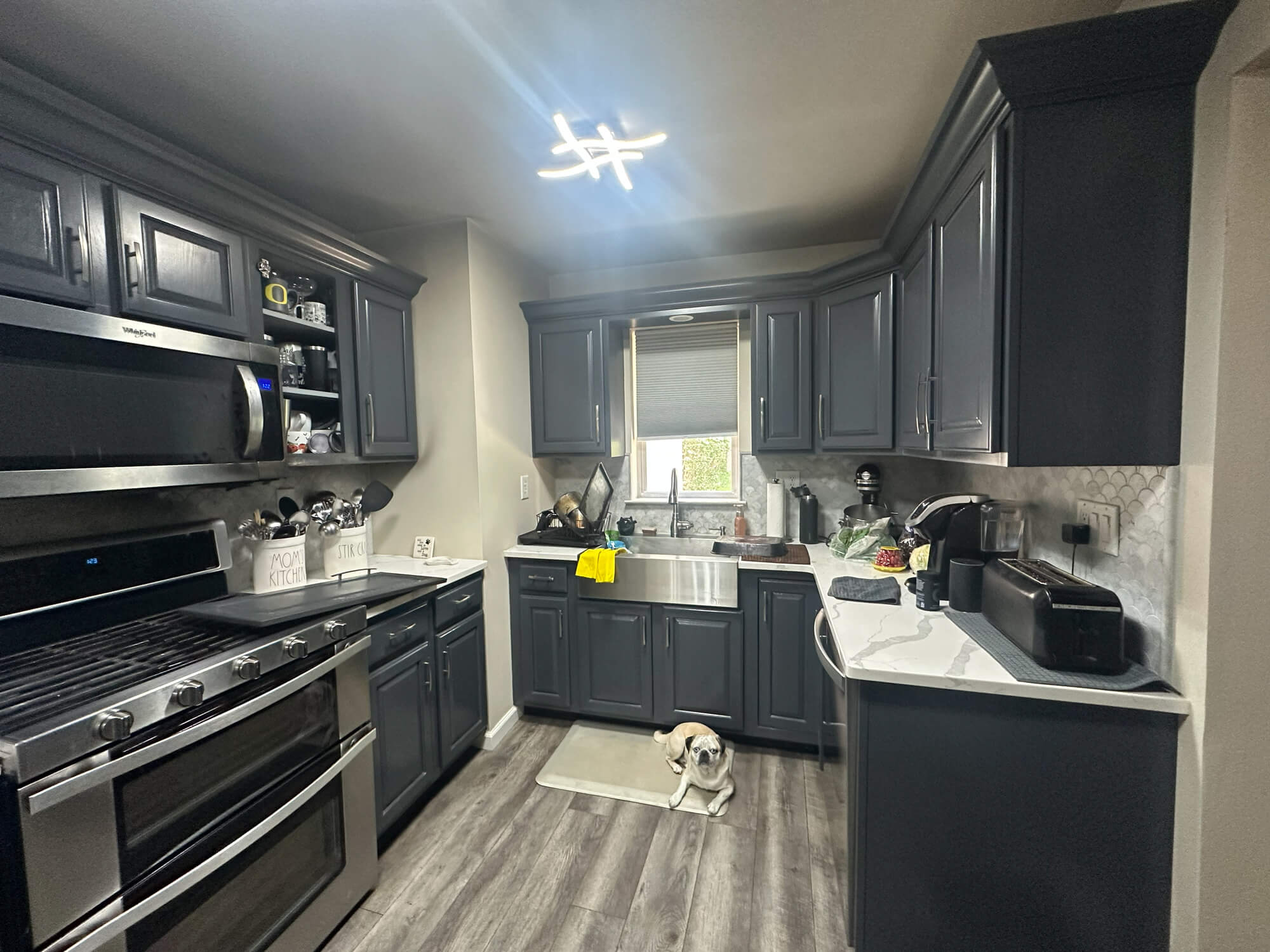 Freshly painted modern kitchen with dark refinished cabinets completed showcasing smooth finishes and detailed craftsmanship.”