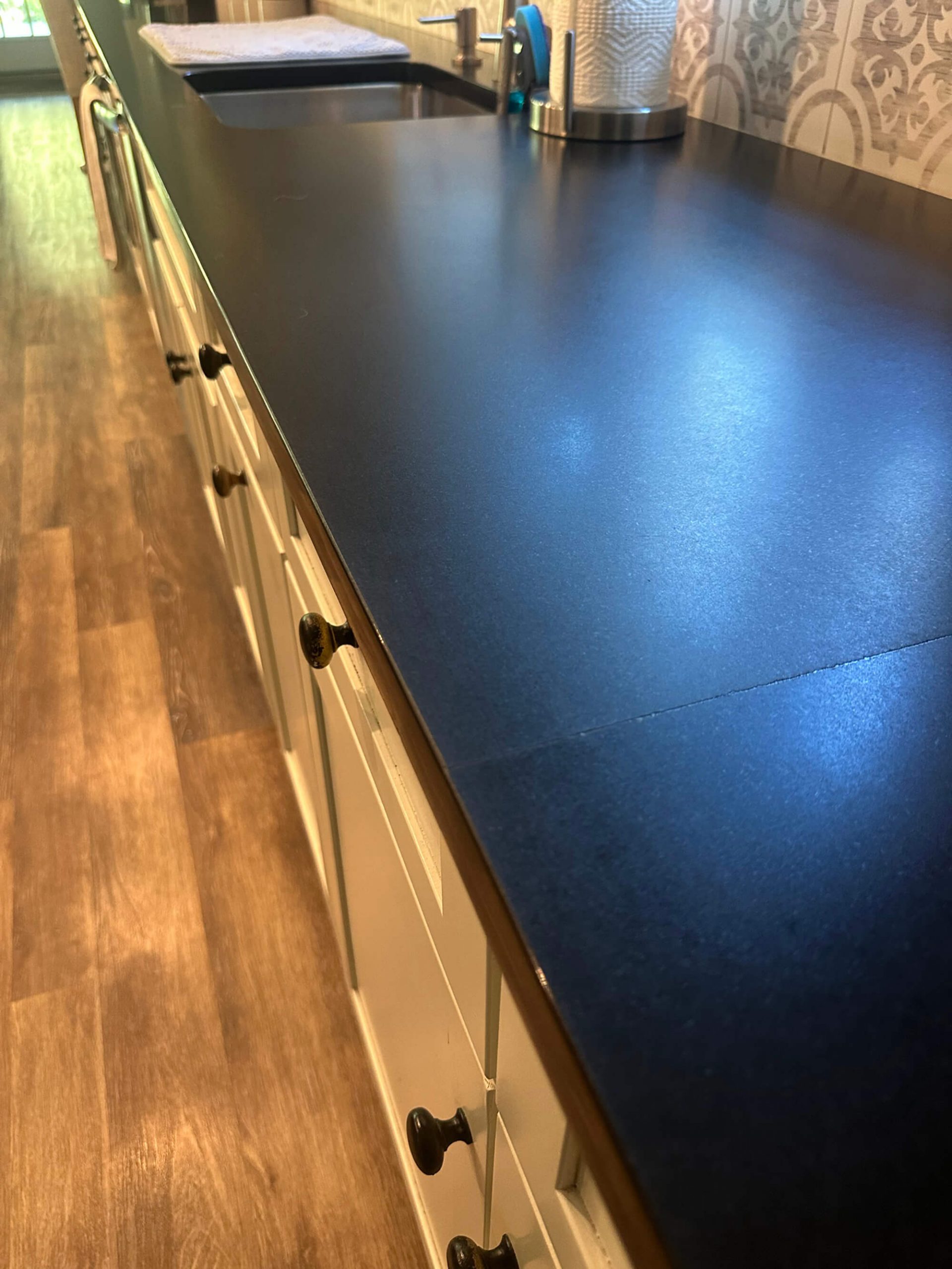 Navy blue painted countertops with white farmhouse cabinets by Willow Tree Painting & Home Improvement
