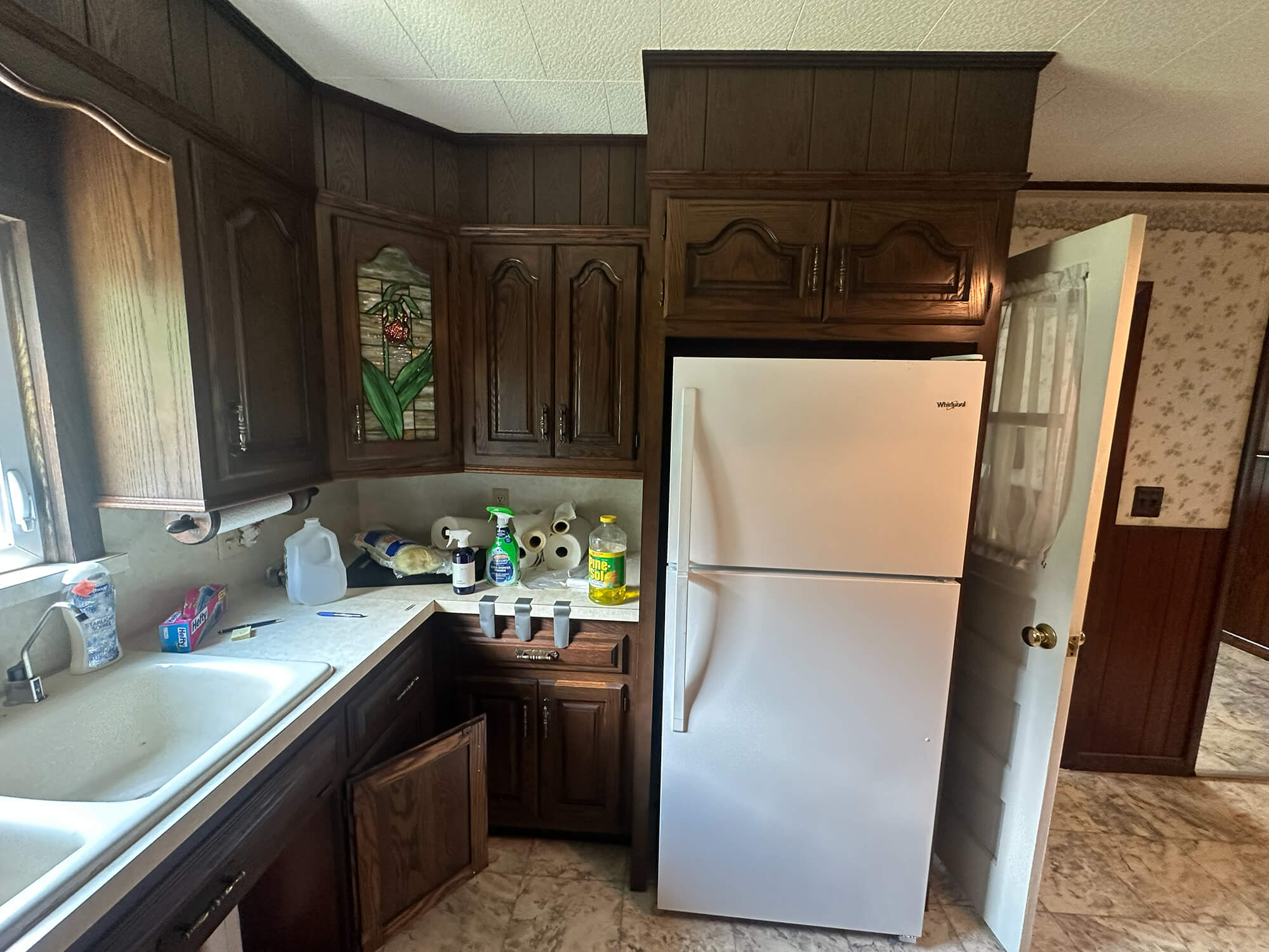kitchen cabinet refinishing project showing old, dark wood cabinets ready for an updated paint job.