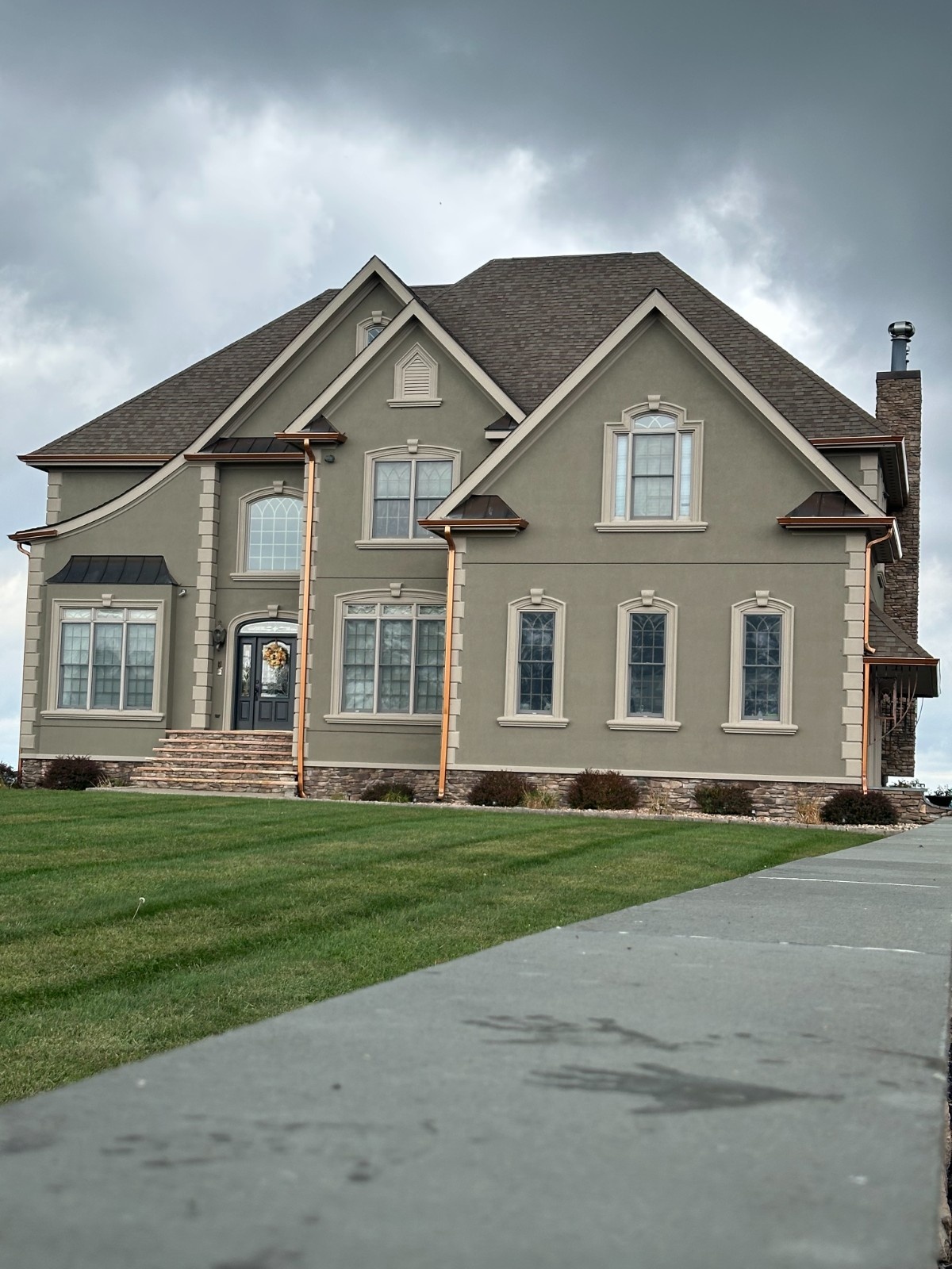 Interior painting and trim work highlighting a deep hunter green fireplace mantel and crown molding against patterned wallpaper.