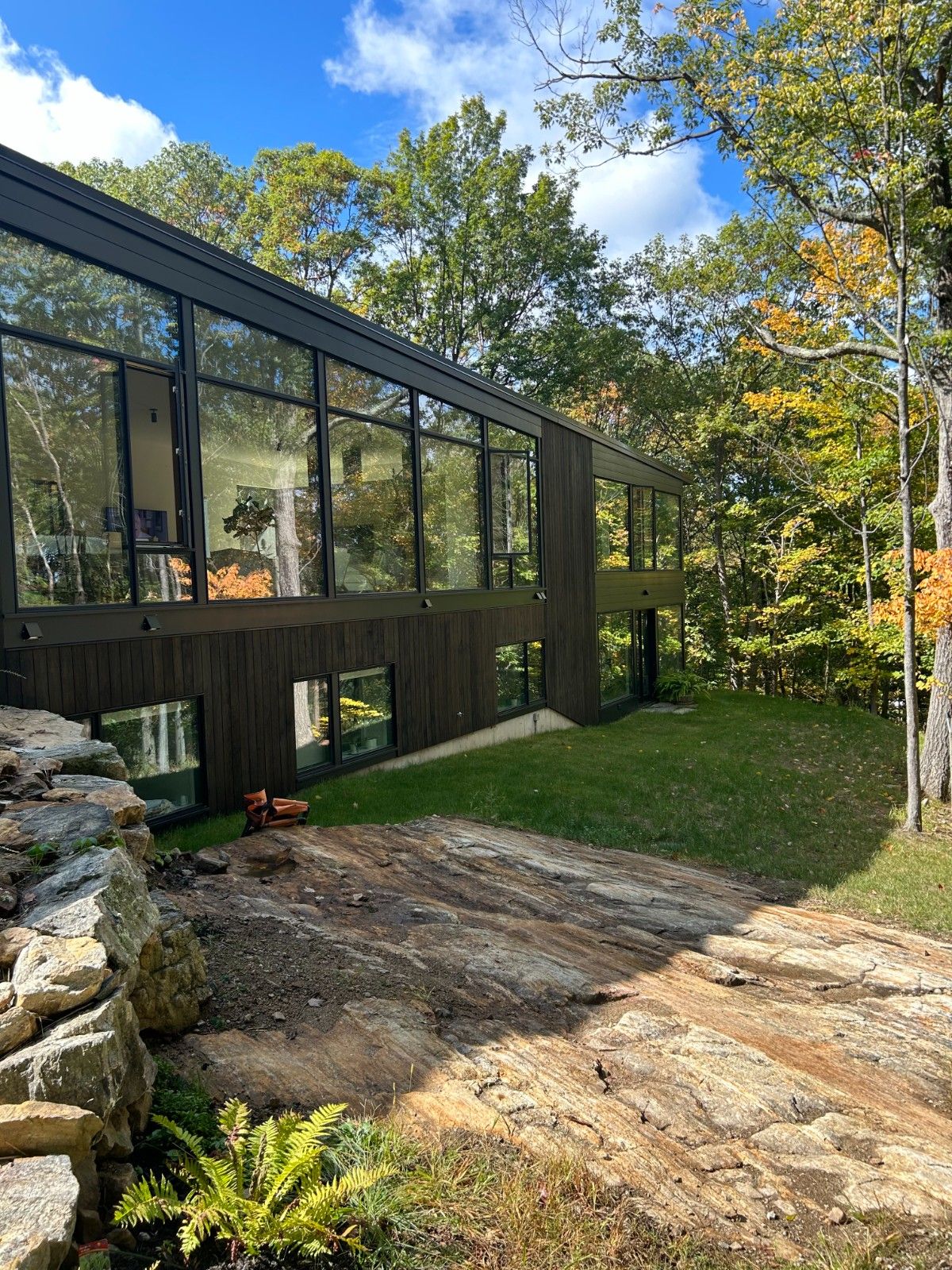 Luxury exterior house painting of a large stucco home in sage khaki with white trim and copper gutter accents.