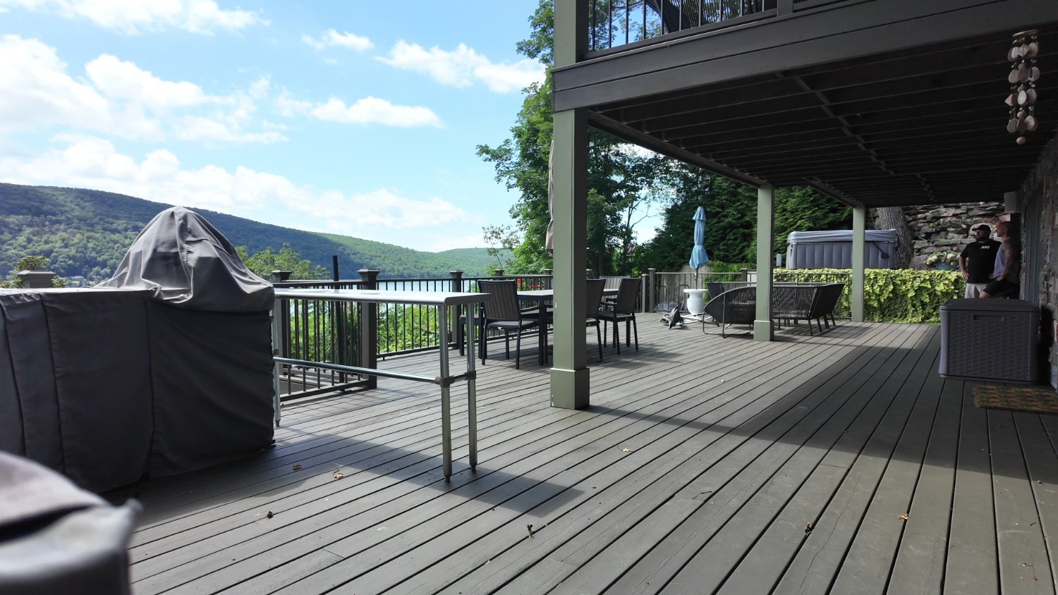 Deck Staining project featuring a large multi-level deck with dark grey finish and a scenic mountain view.