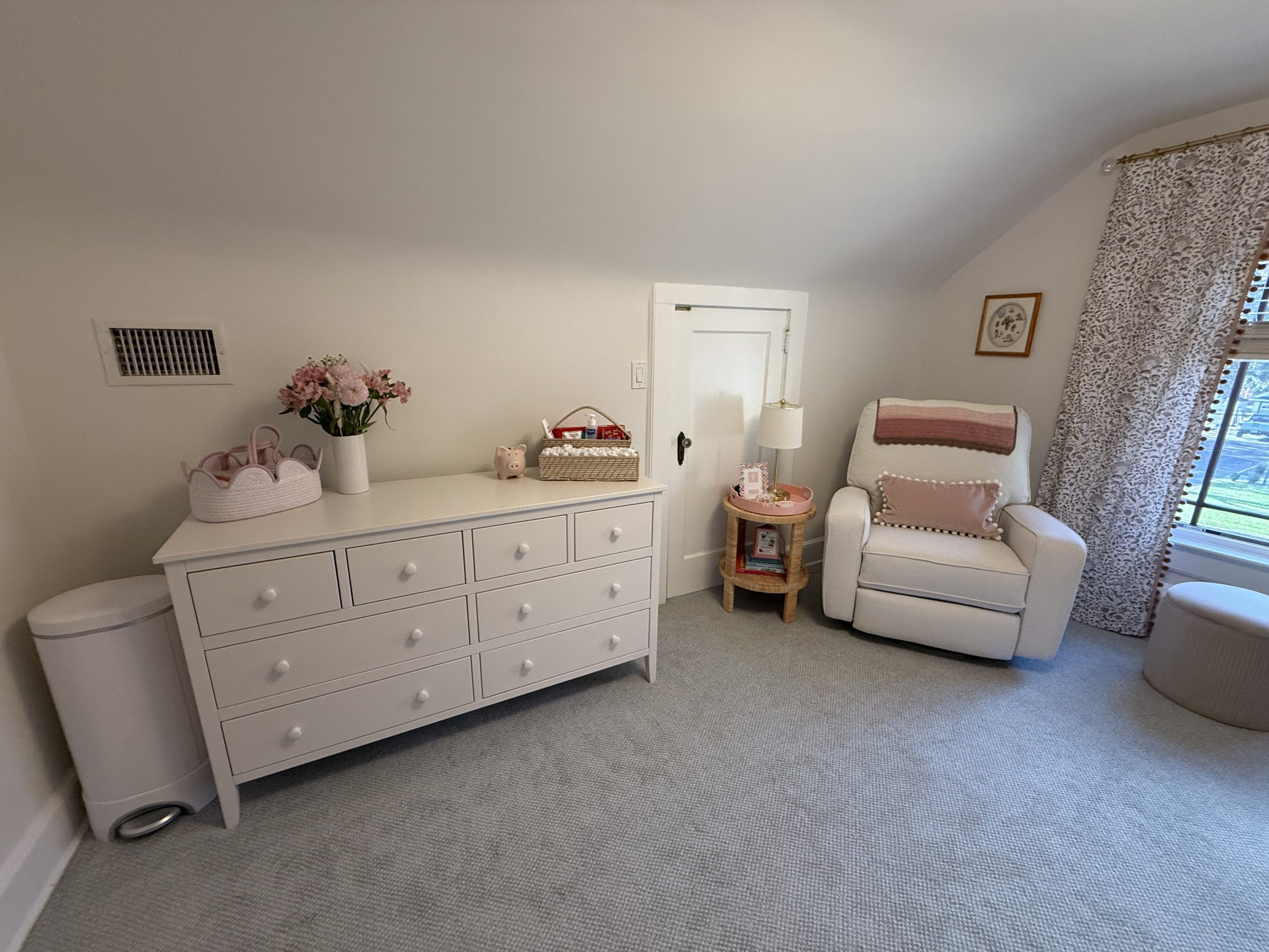 Home Improvement interior painting of a beautiful, bright nursery with crisp white walls, white furniture, and a cozy glider chair.