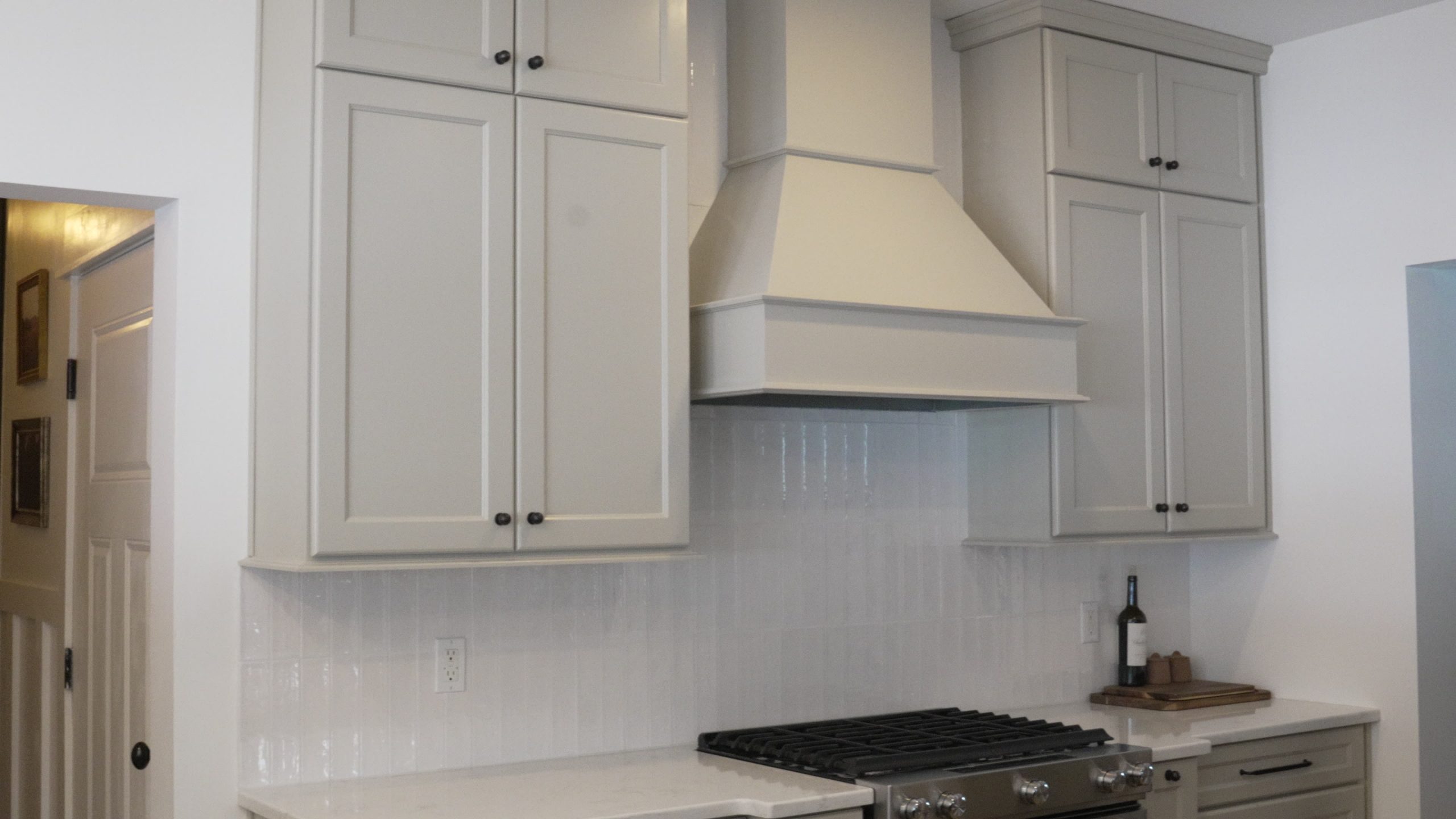 High Quality Cabinet Painting Finish New York New Jersey on luxury greige cabinets with a custom-painted range hood.